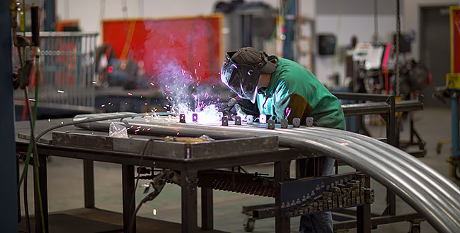 Manufacturing employee working on a piece of a playground structure.