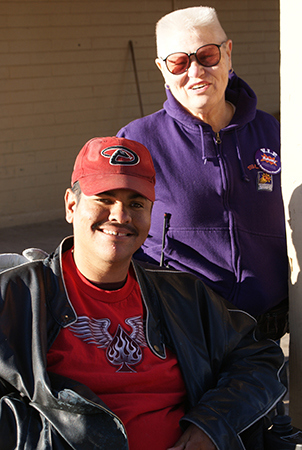 A boy and a woman smile at the camera. 